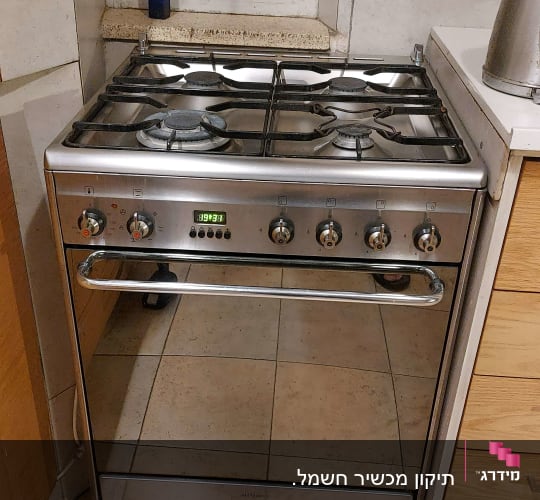 תנור גז עם כפתורים ומד טמפרטורה במטבח